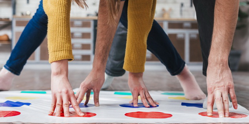 Twister žaidimas - žmonės ant kilimėlio